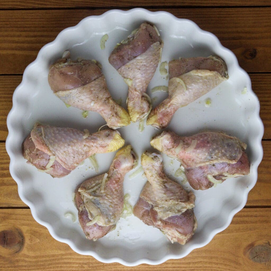 How to place chicken drumsticks in a pie pan for kljukuša with potatoes